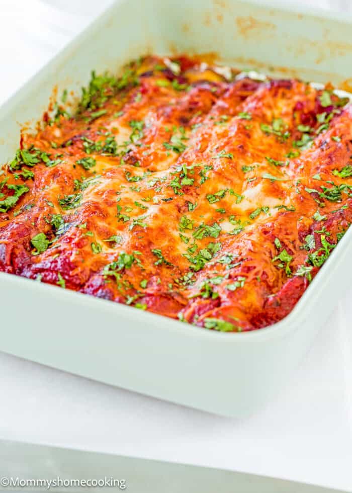 Easy Eggless Cheese Manicotti in a baking dish with chopped basil on top.