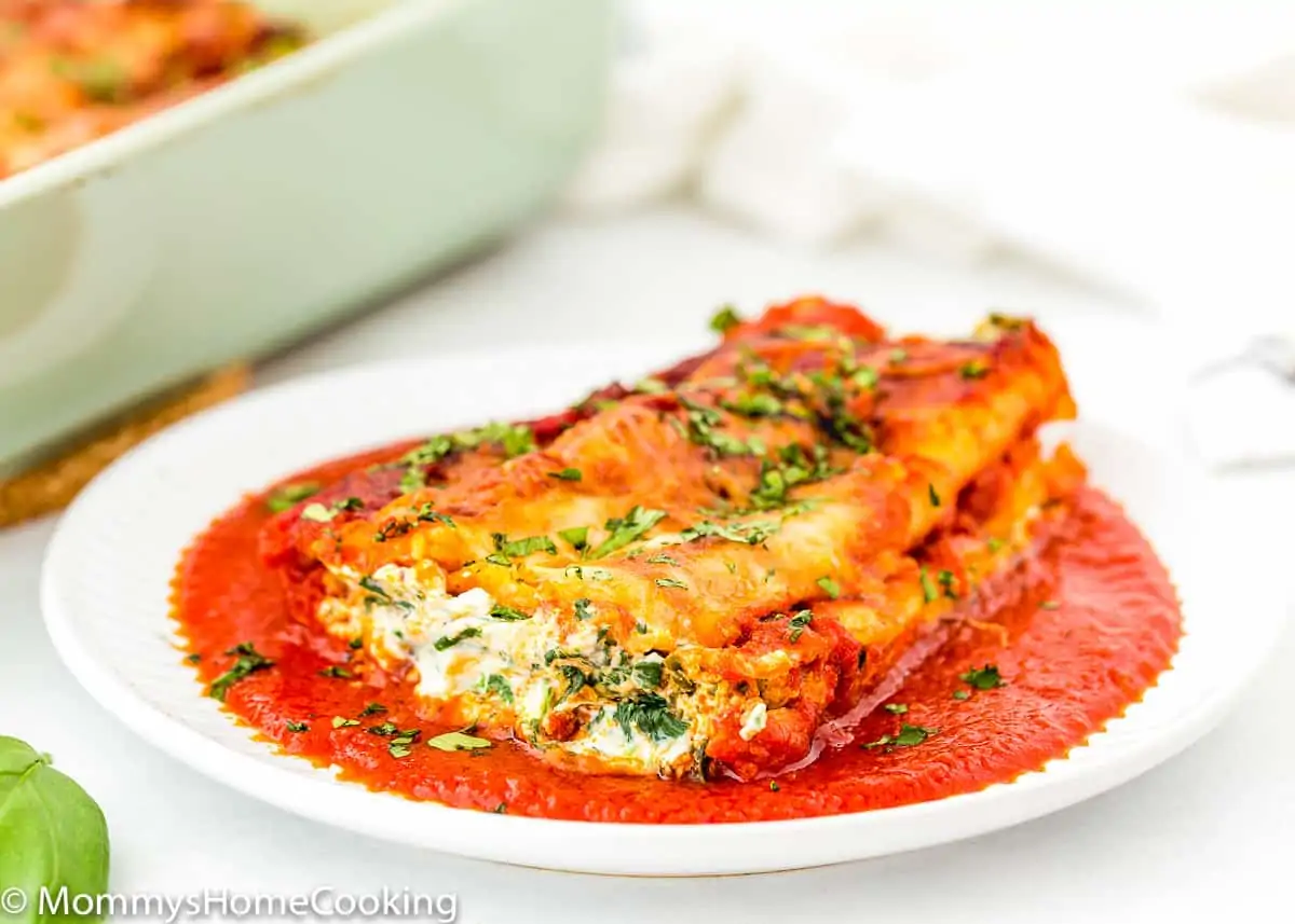 cheese manicotti in a plate garnished with fresh basil