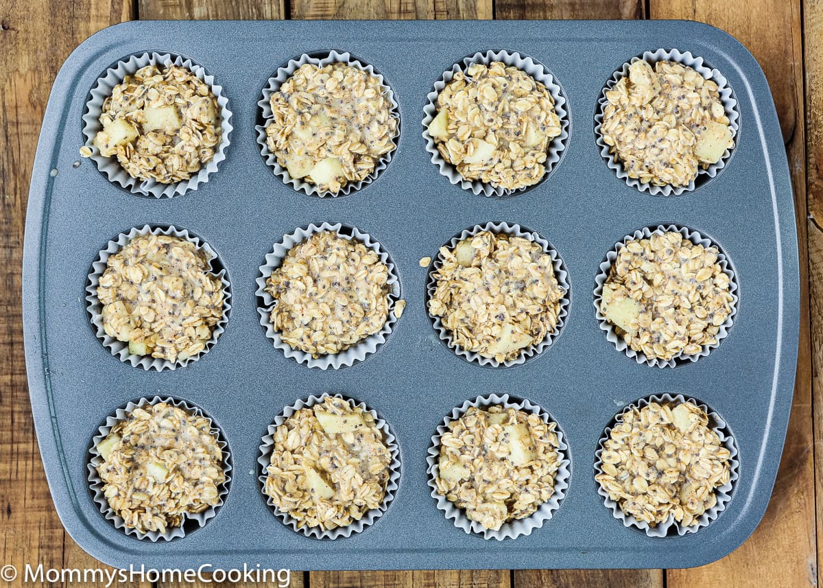 overhead view of a muffin pan with egg-free baked apple oatmeal muffins batter in it
