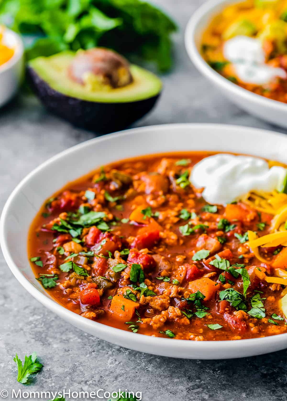 a bowl with Healthy Low Carb Turkey Chili topped with sour cream and cheese.