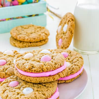 eggless oatmeal sandwich cookies on a plate wit a milk glass on the background.