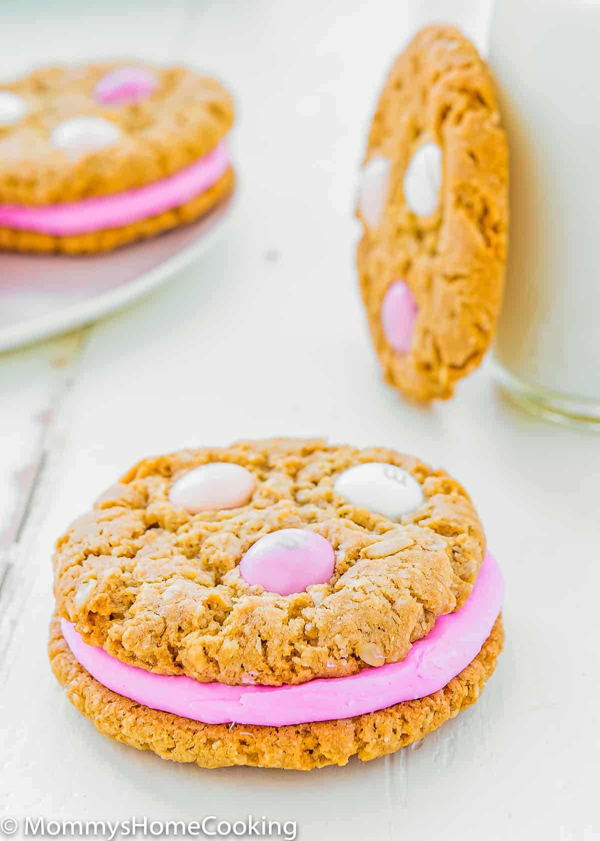 one two egg-free oatmeal sandwich cookie with pin frosting.