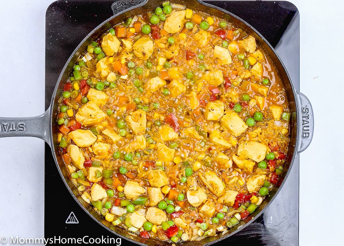arroz con pollo being cooked in a skillet.