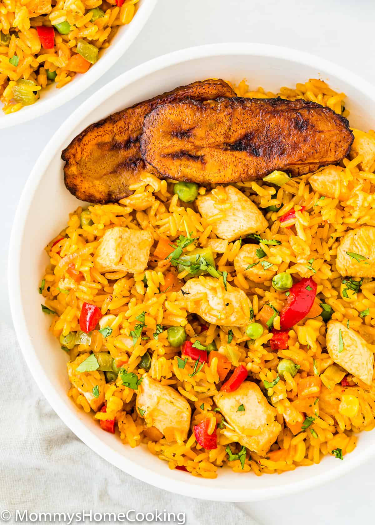 a plate of arroz con pollo with plantains.