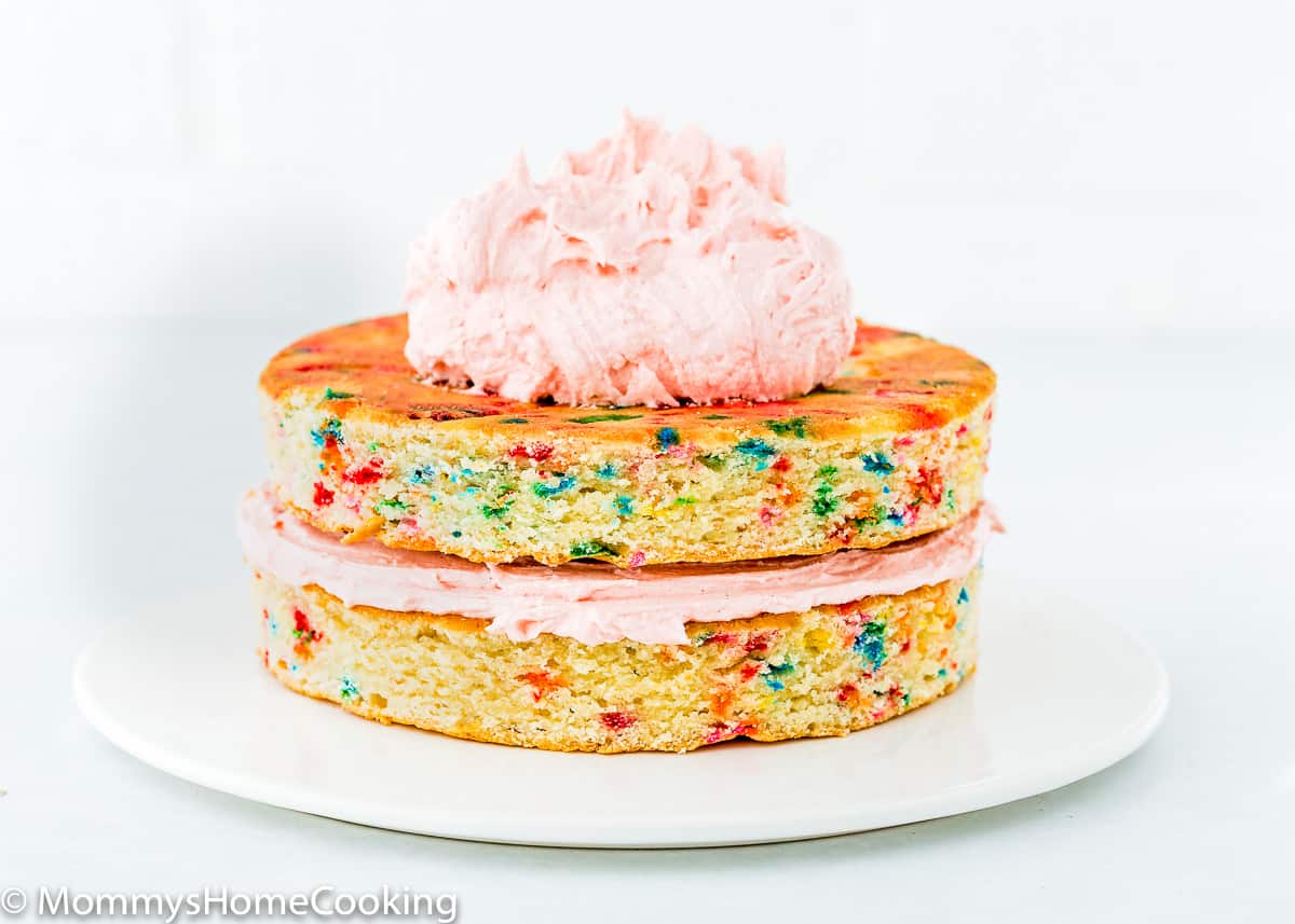 two cake layers of egg-free confetti cake with buttercream on top.
