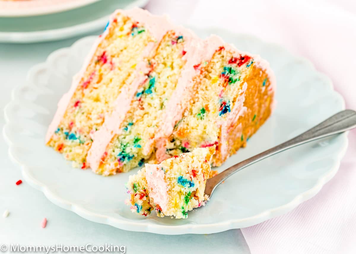egg-free funfetti cake slice on a plate with a fork on the side.