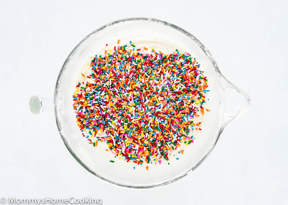 sprinkles over eggless cake batter in a mixing bowl.