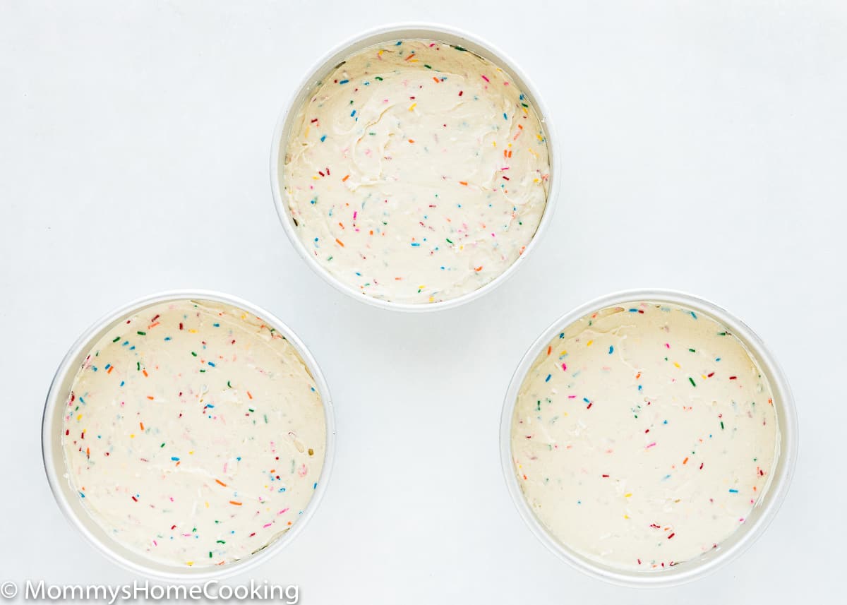 three cake pans filled with egg-free cake batter.