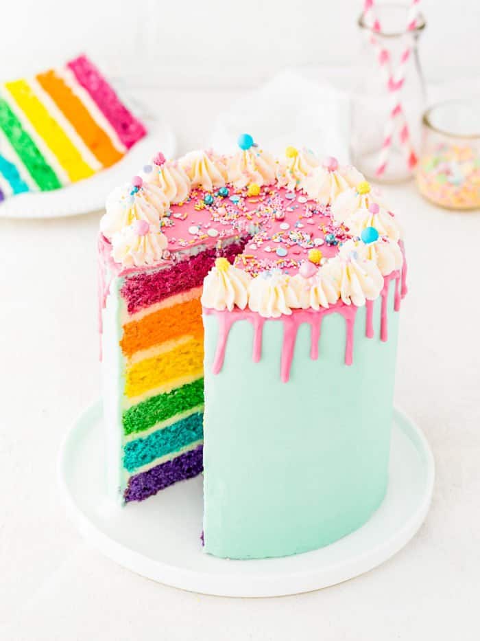 egg-free rainbow cake sliced in a serving plate.