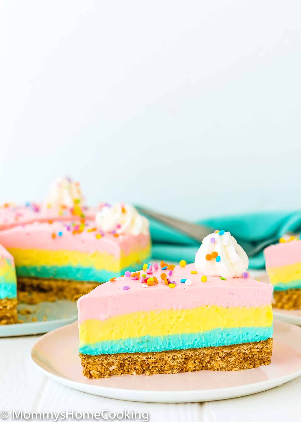no-bake easter cheesecake slice on a plate with whipped cream and sprinkles.
