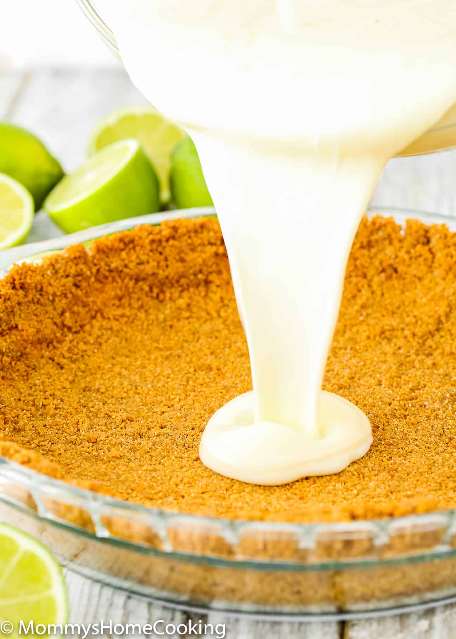 egg-free key lime filling being poured over a graham cracker crust.