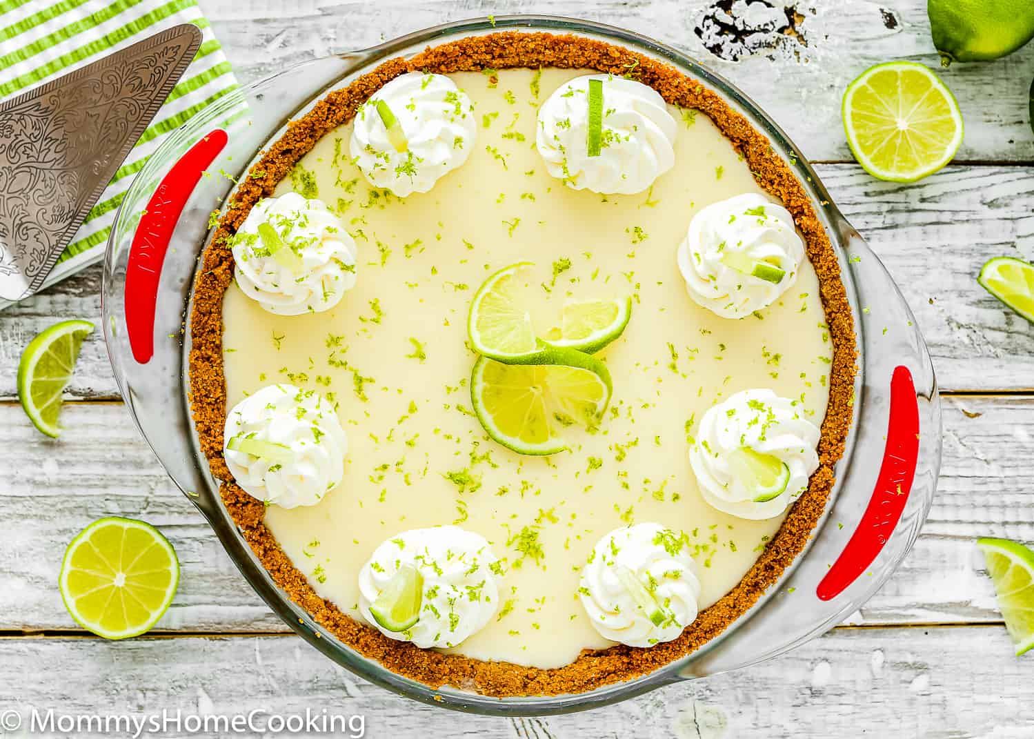 egg-free key lime pie with whipped cream and fresh lime zest on top in a pie dish.