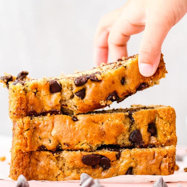 a child hand holding a slice of eggless Eggless Zucchini Bread.