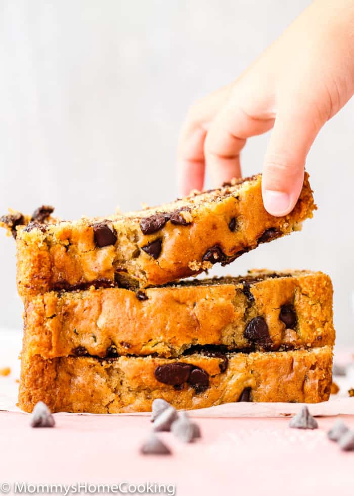 a child hand holding a slice of eggless Eggless Zucchini Bread.