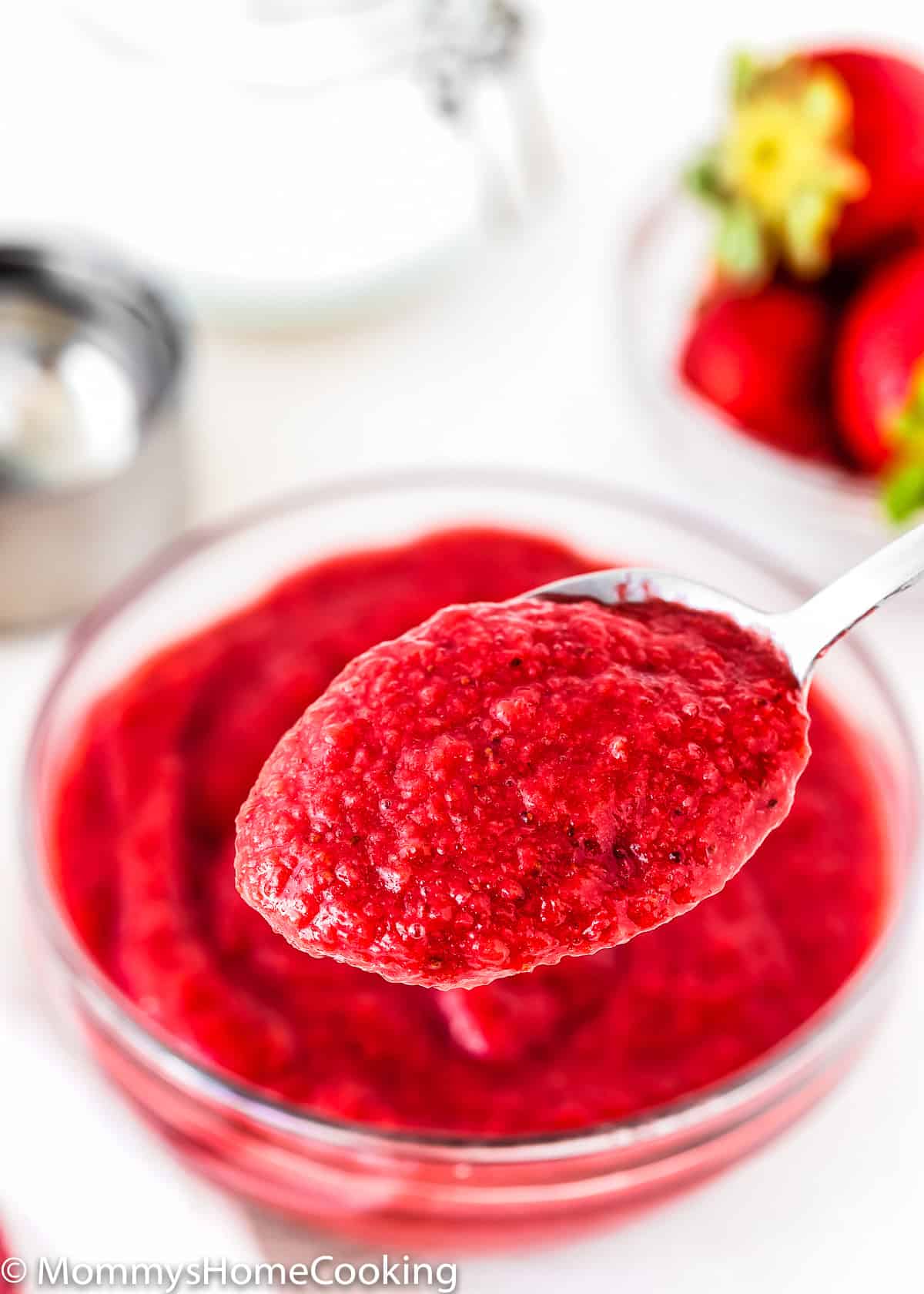 a spoon showing homemade strawberry puree texture.
