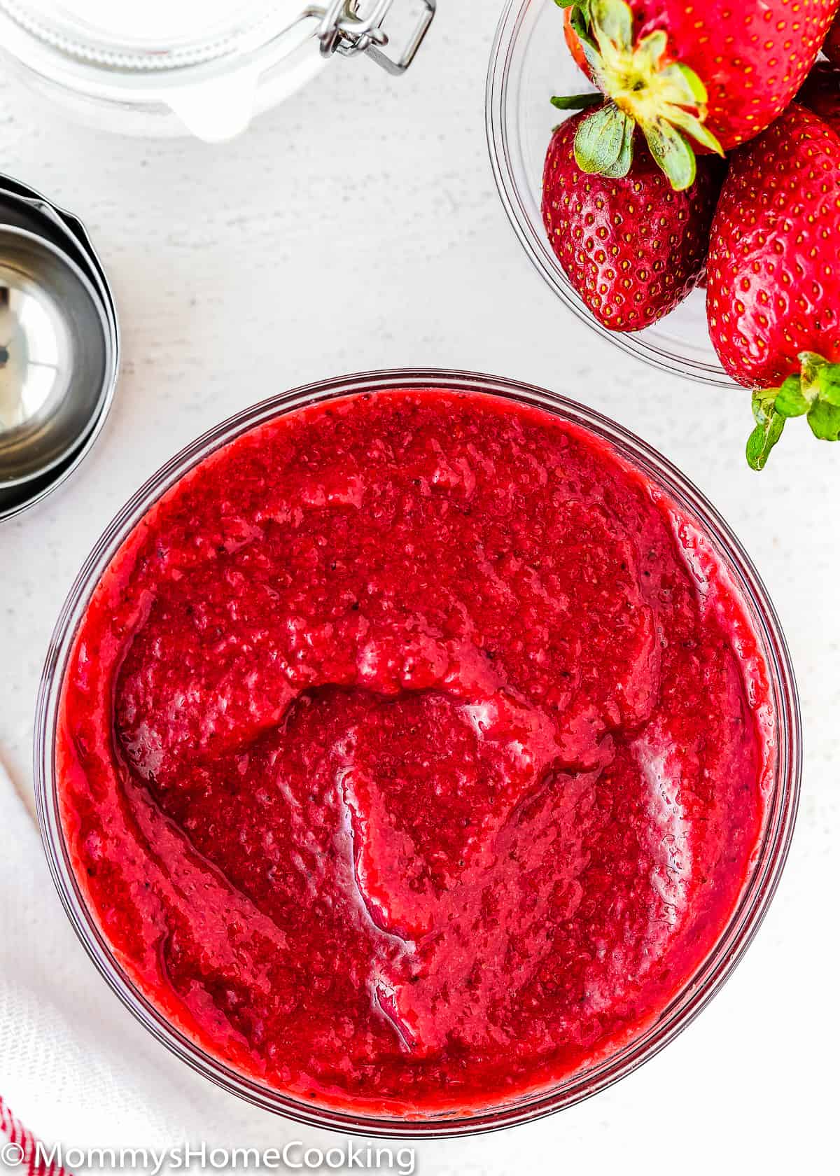 a glass bowl filled with homemade strawberry puree.