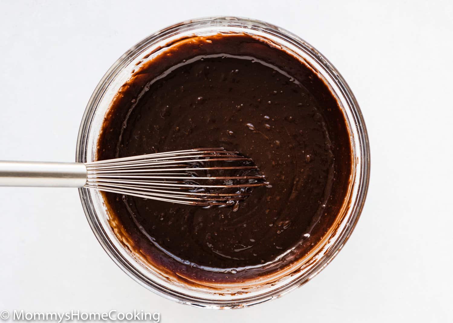 eggless brownie batter in a bowl with a whisk.