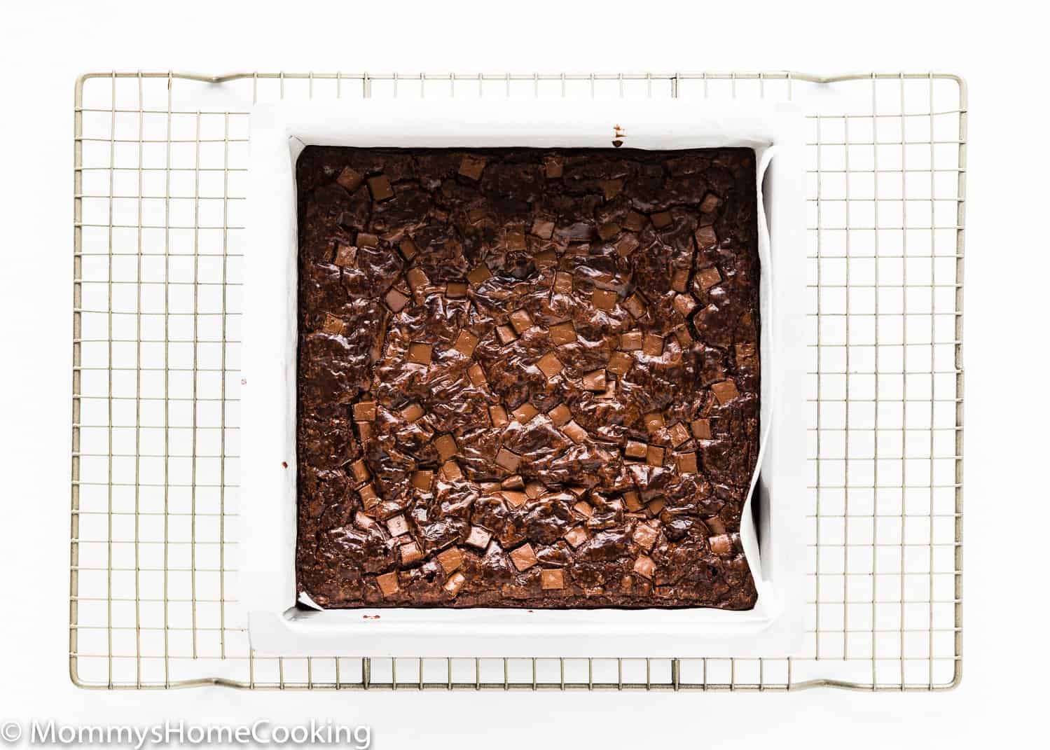 baked egg-free brownies in a square pan over a cooling rack.