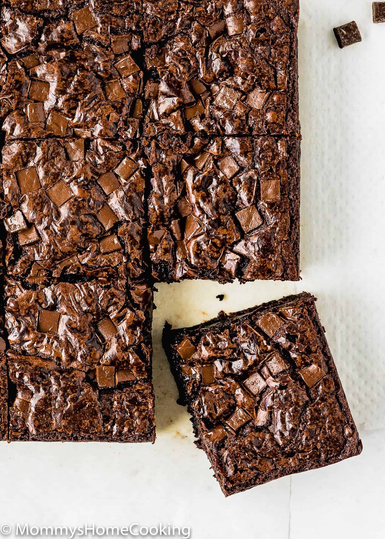 eggless brownies with crackly top cut over parchment paper.