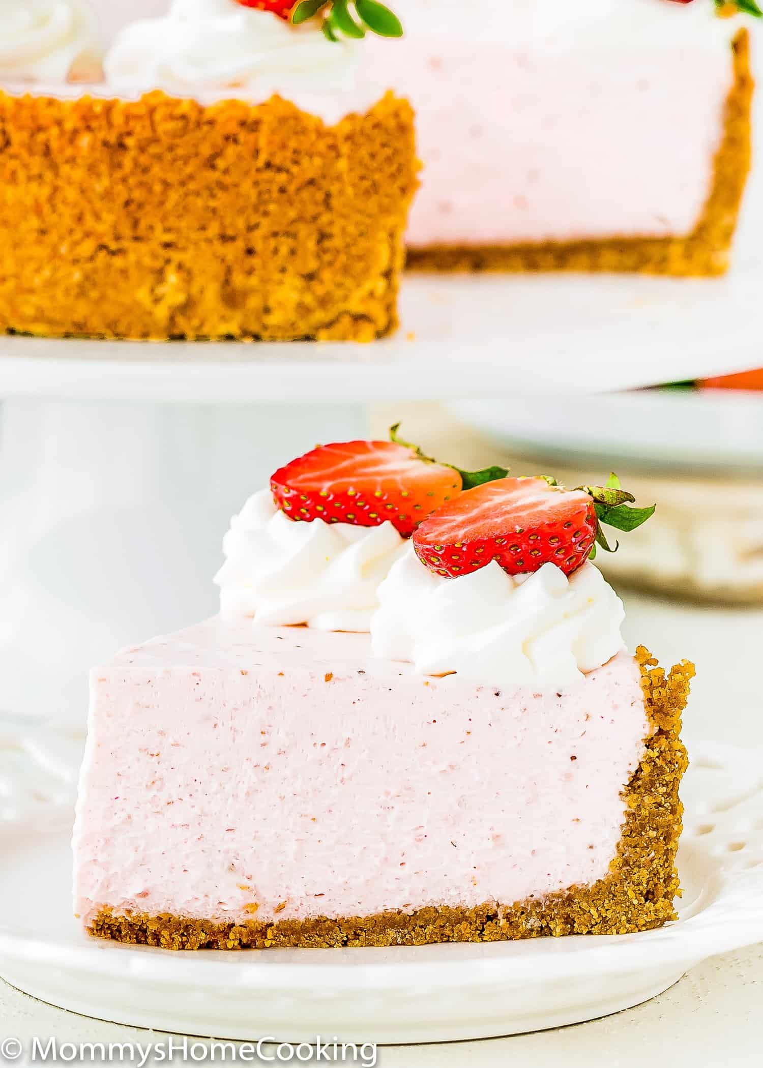 a slice of No-Bake Strawberry Cheesecake with fresh strawberries and whipped cream on top.