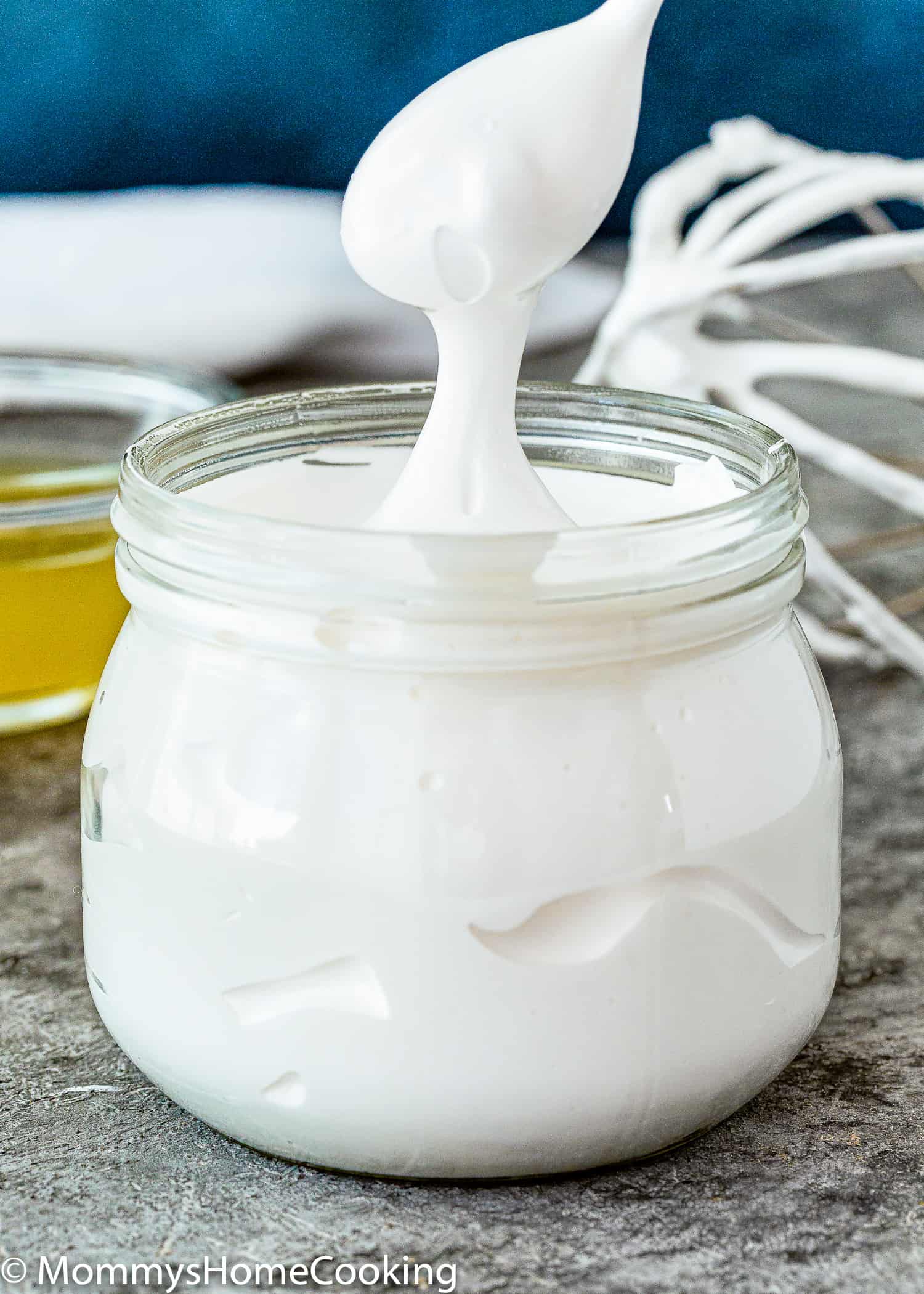 a spoon showing how stretchy and perfect Homemade Eggless Marshmallow Fluff is.