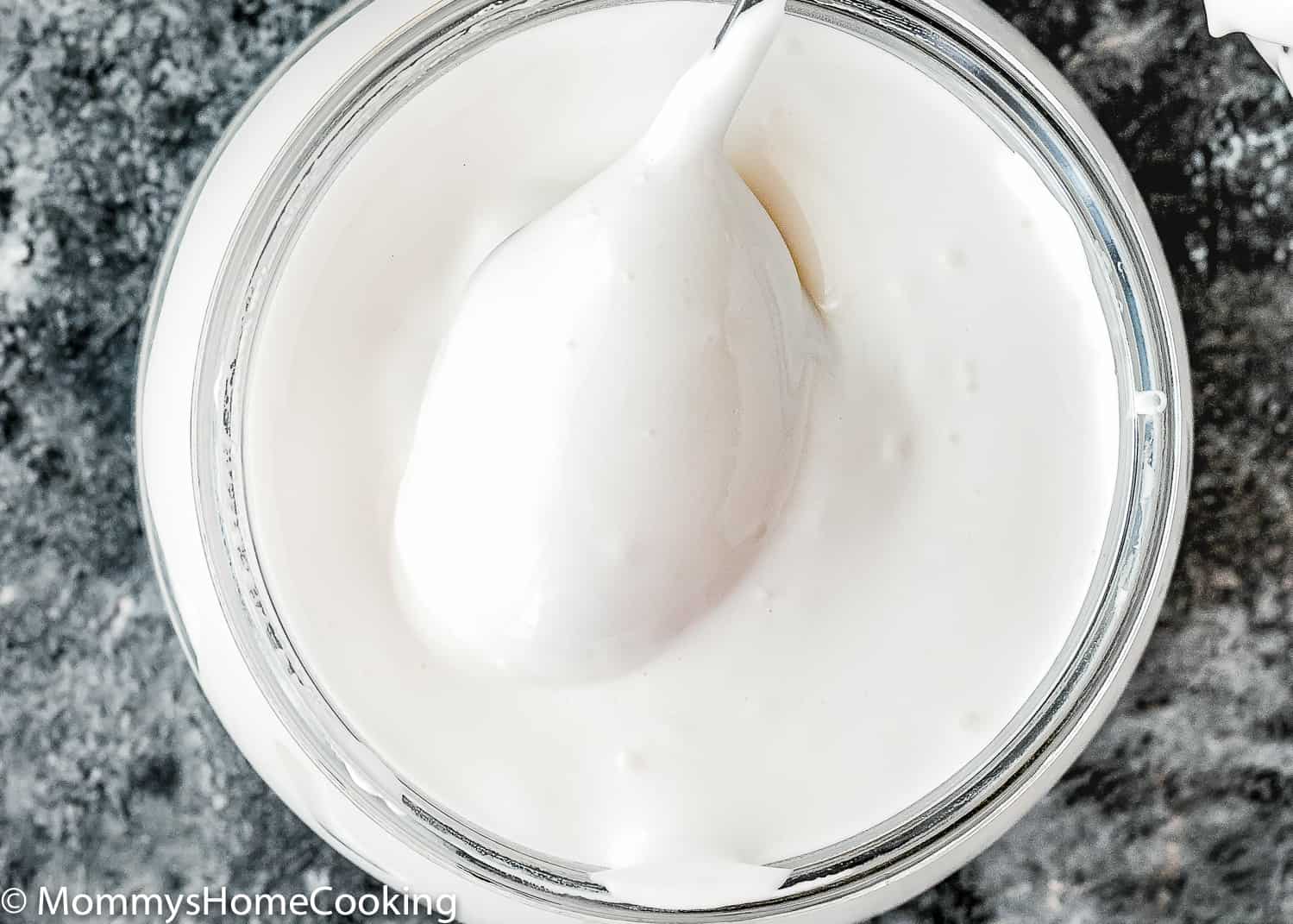 a spoon covered with Homemade Eggless Marshmallow Fluff.