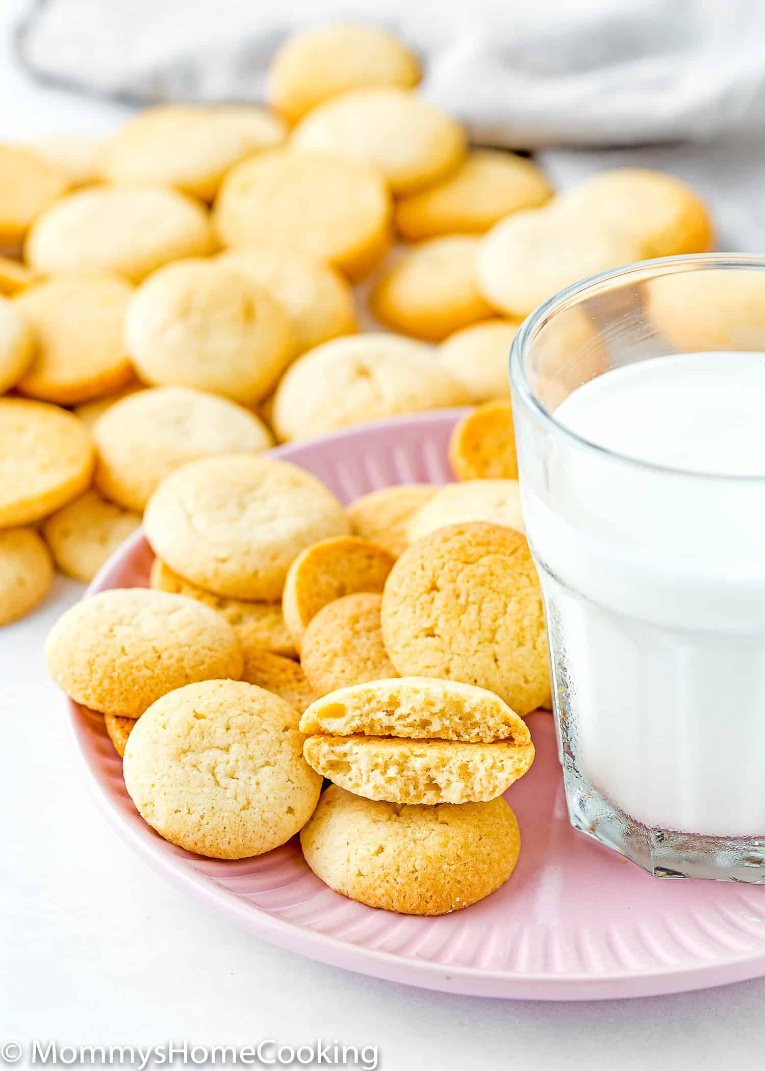 Eggless Vanilla Wafers (Nila Wafers) on a pink plate with a glass of milk on the side.