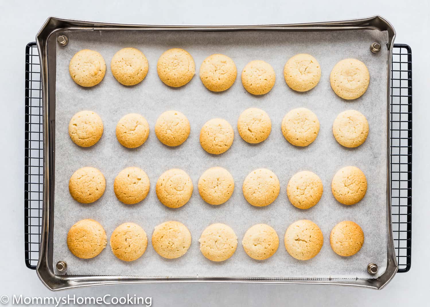 baked Eggless Vanilla Wafers in a baking tray over a cooling rack.