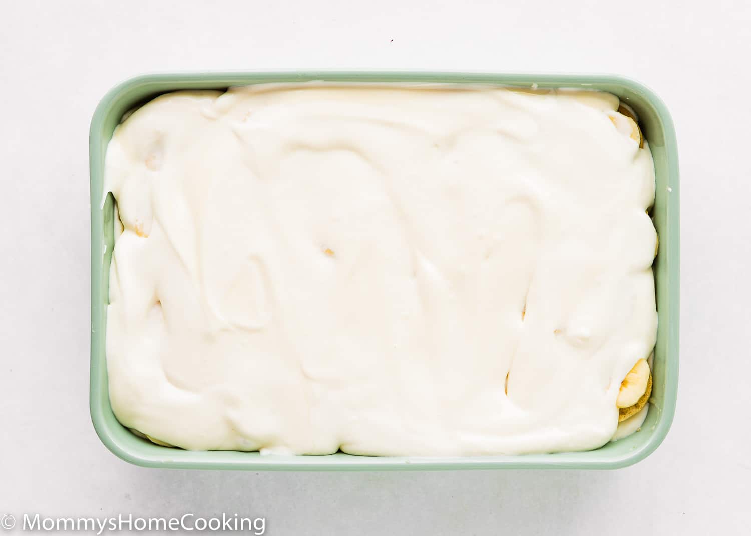 Homemade eggless banana pudding in a green rectangular dish.