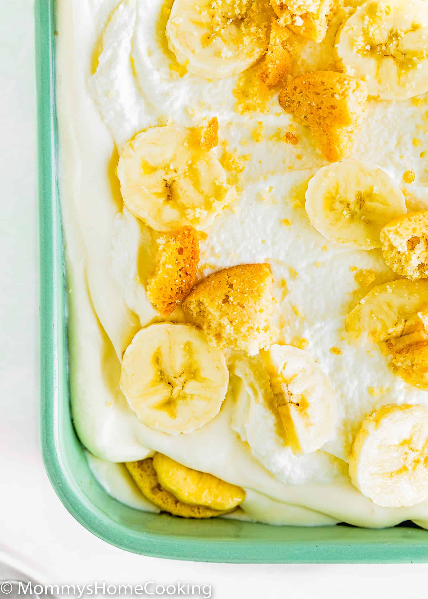 Egg-free banana pudding in a green dish showing its layers.