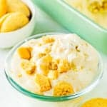 eggless banana pudding in a small bowl with wafer around and a big rectangular dish in the background.