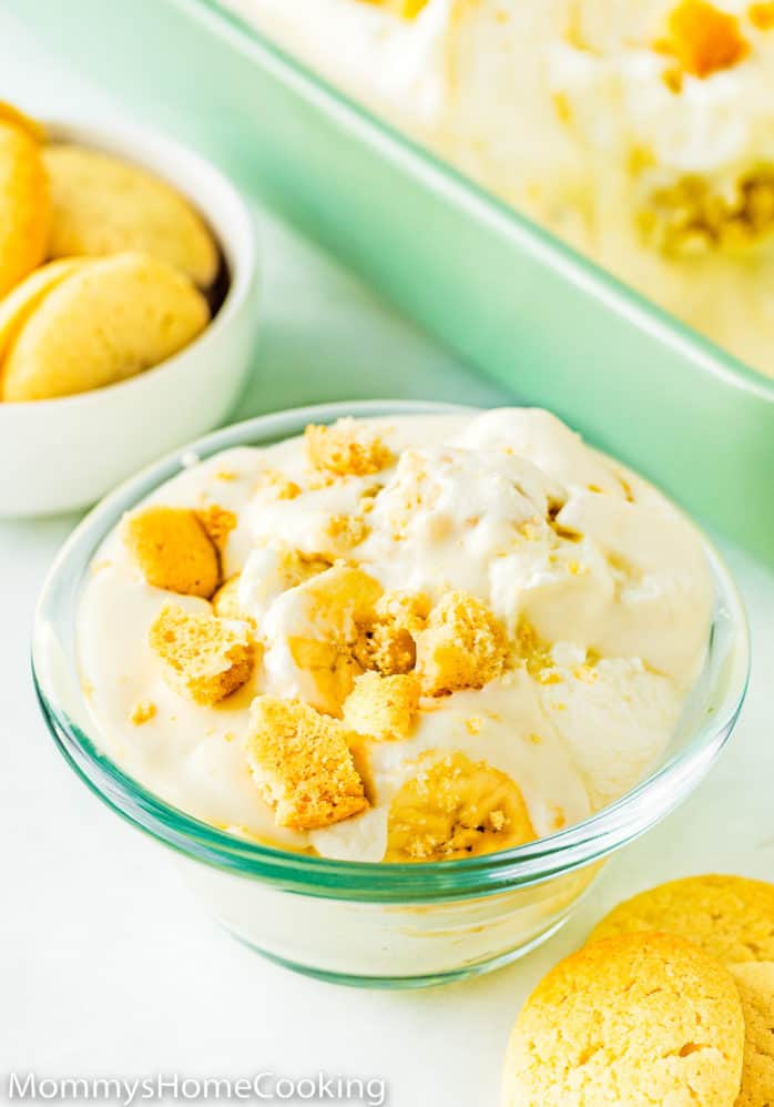 eggless banana pudding in a small bowl with wafer around and a big rectangular dish in the background.