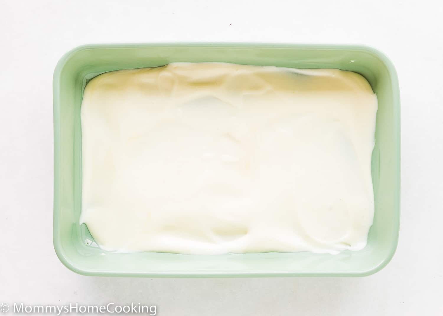 A rectangular green dish with pudding on the bottom.