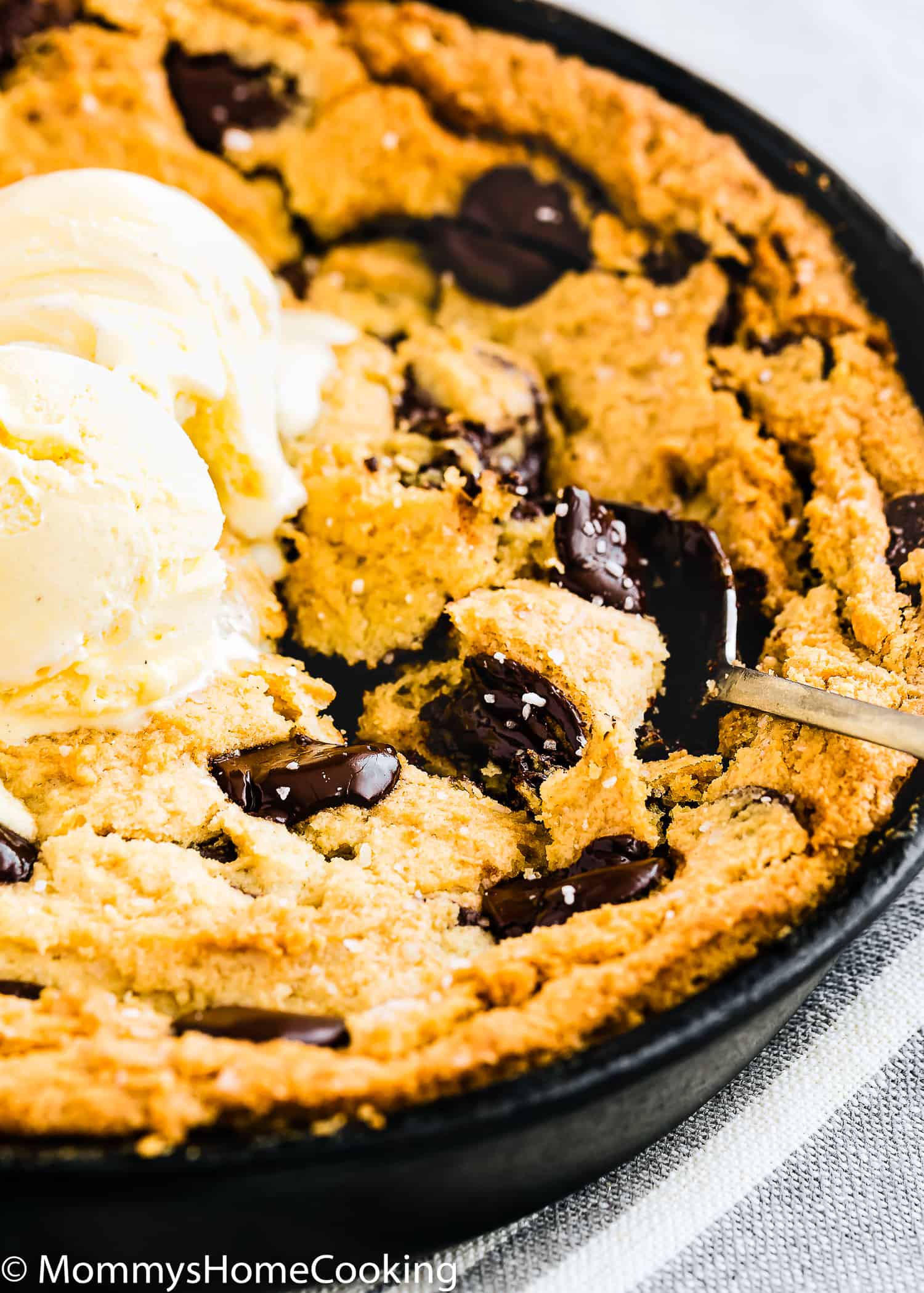 a spoon scooping Eggless Chocolate Chip Skillet Cookie.