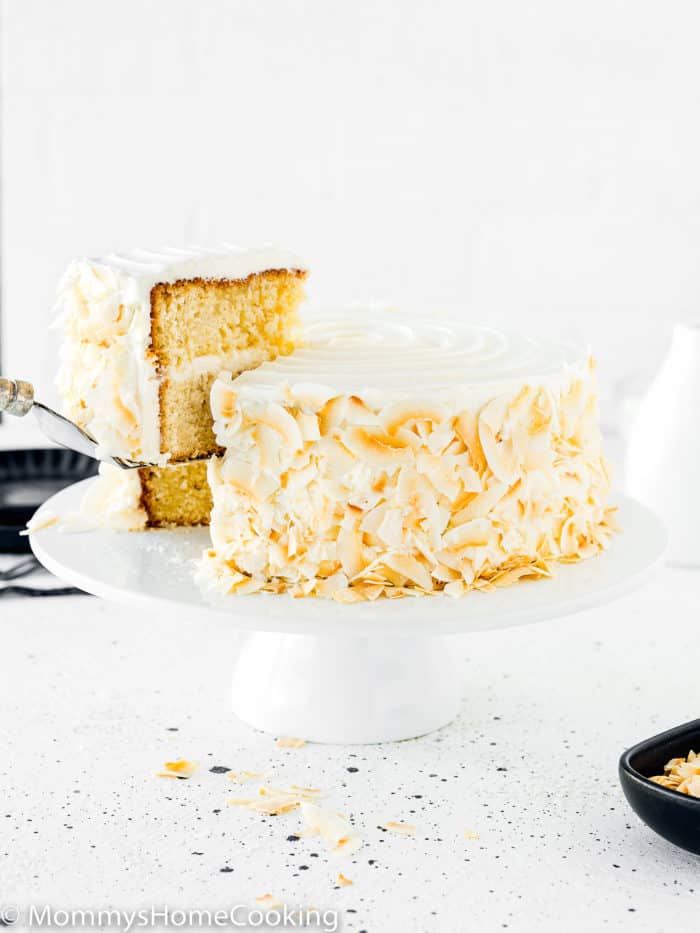 a cake server lifting a slice of Eggless Coconut Cake.