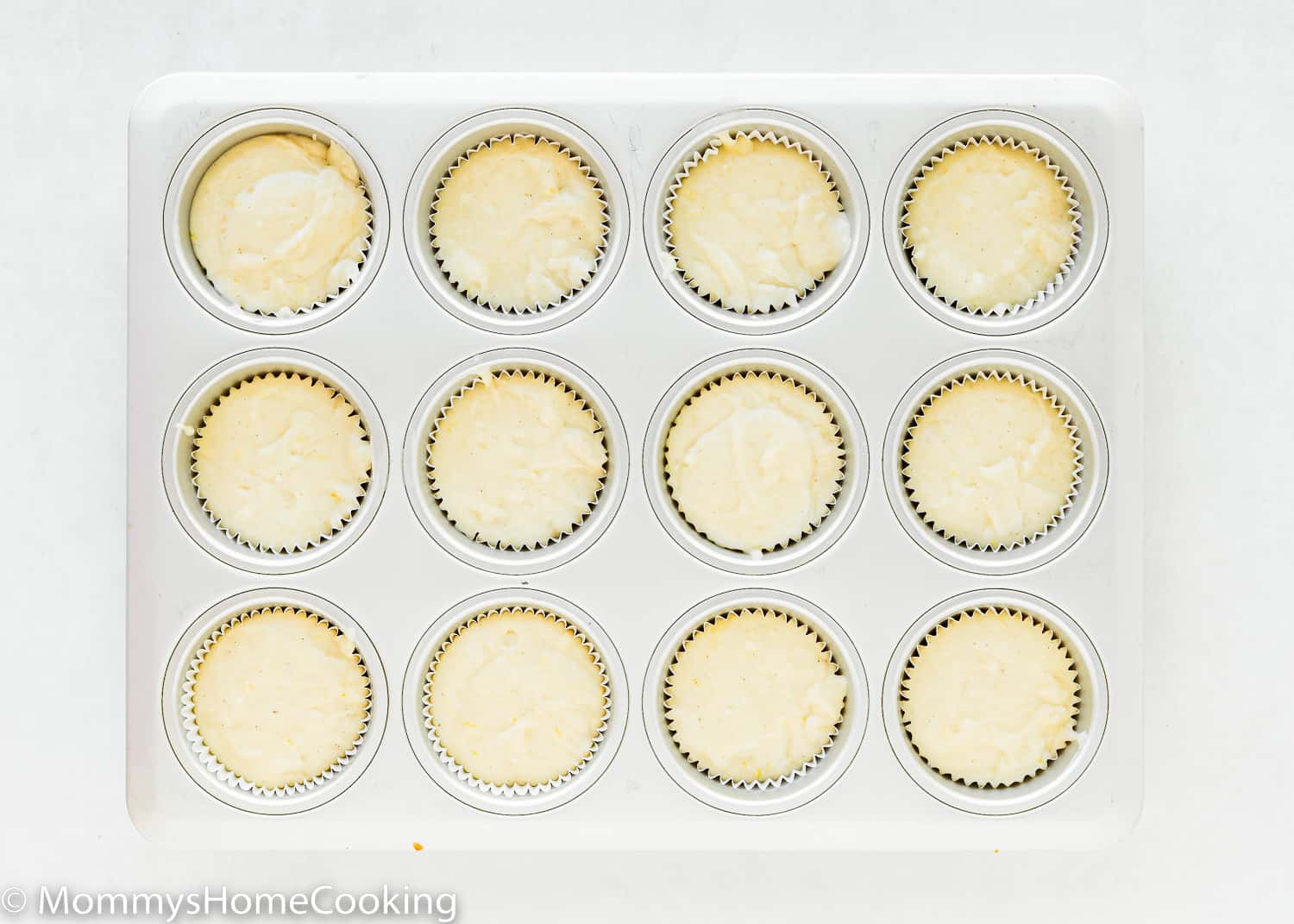 muffing tin with Eggless Lemon Muffins batter.