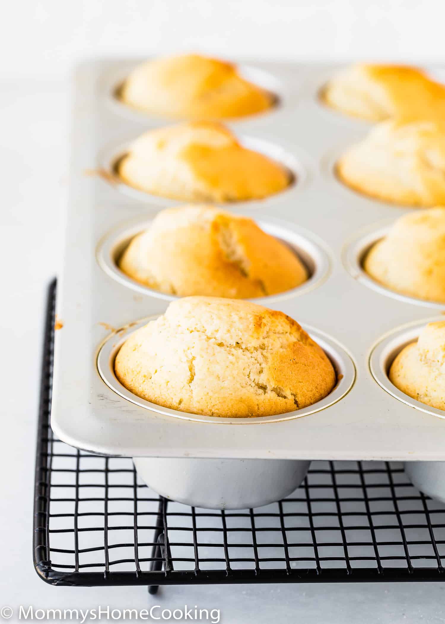 Egg-free Lemon Muffins in a muffin pan over a cooling rack.