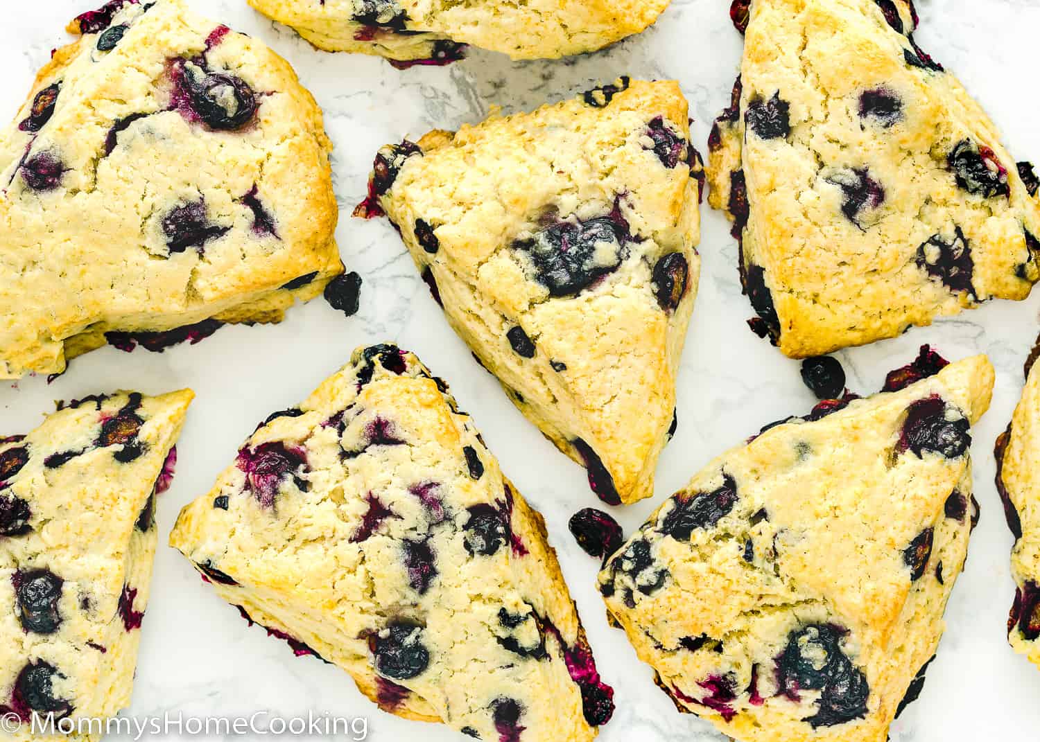 Baked Eggless Blueberry Scones over a marble surface.