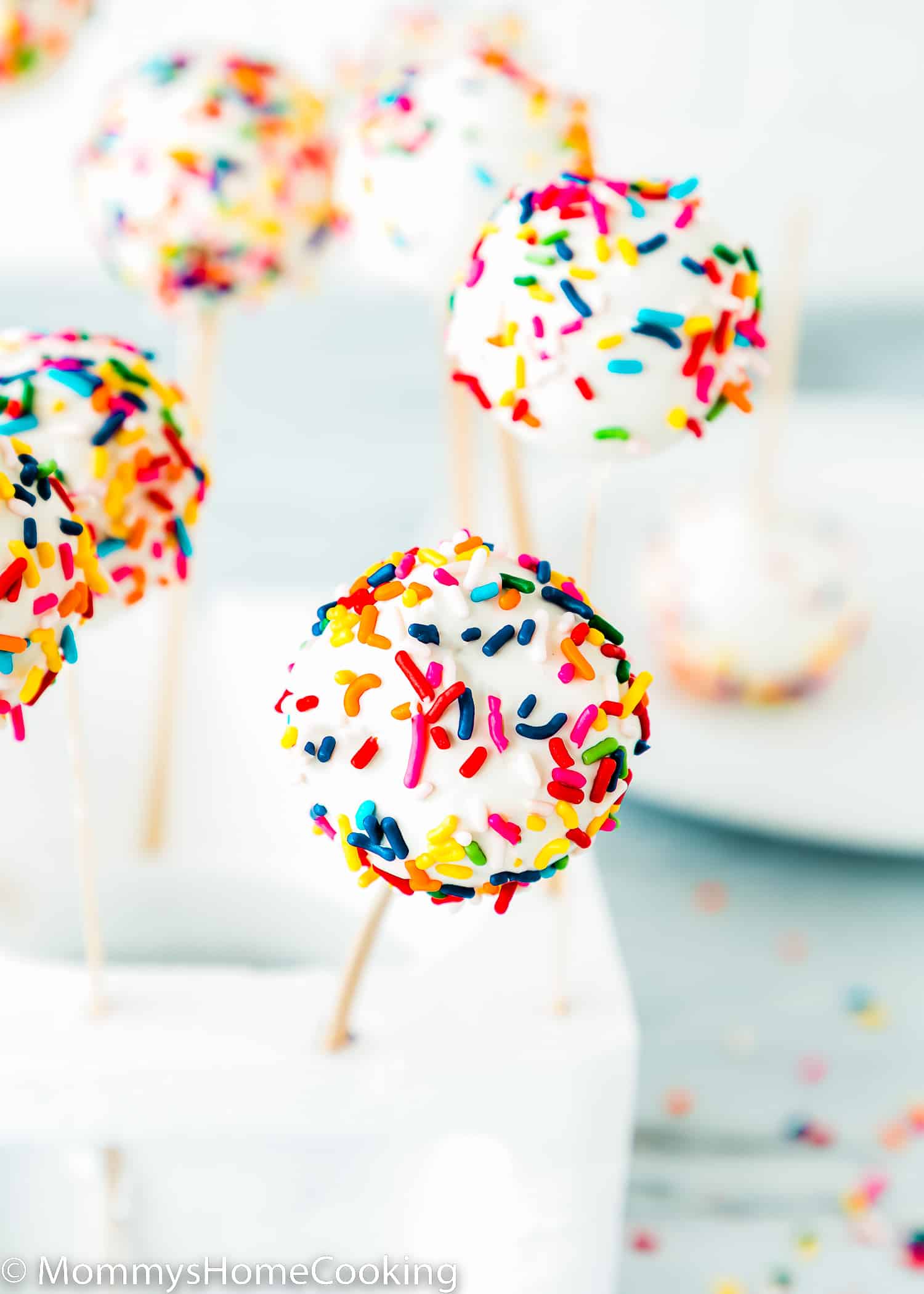 a homemade eggless cake pop covered with sprinkles in a styrofoam block.