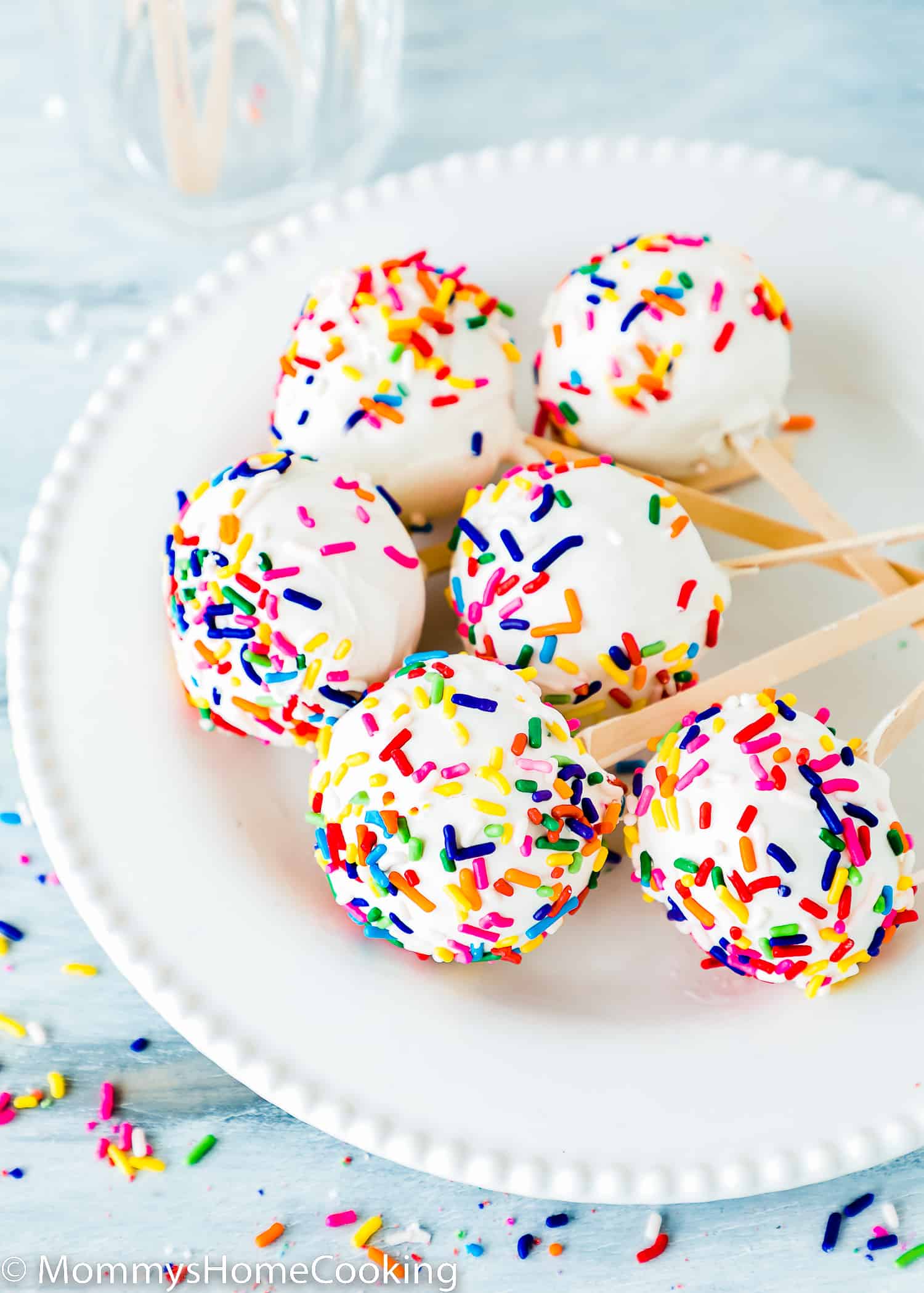 homemade egg-free cake pops on a plate covered with Sprinkles.