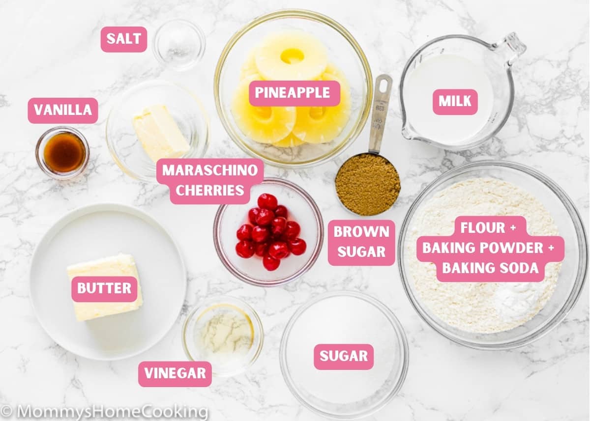 Ingredients needed to make Eggless Pineapple Upside-Down Cake over a marble surface with name tags. 