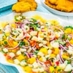 Fish ceviche with mango in a big serving plate with tostones on the side.
