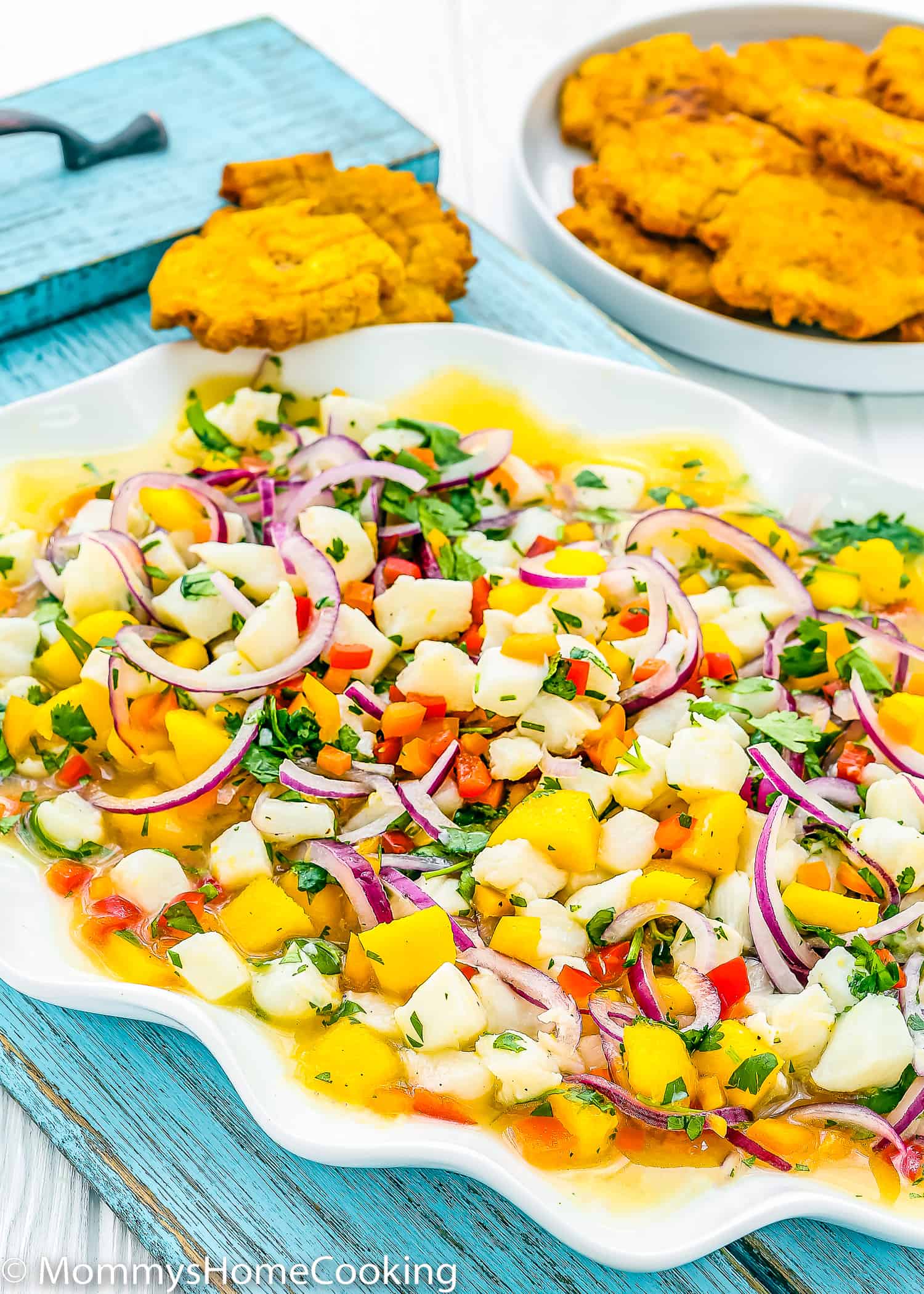 Fish ceviche with mango in a big serving plate with tostones on the side.