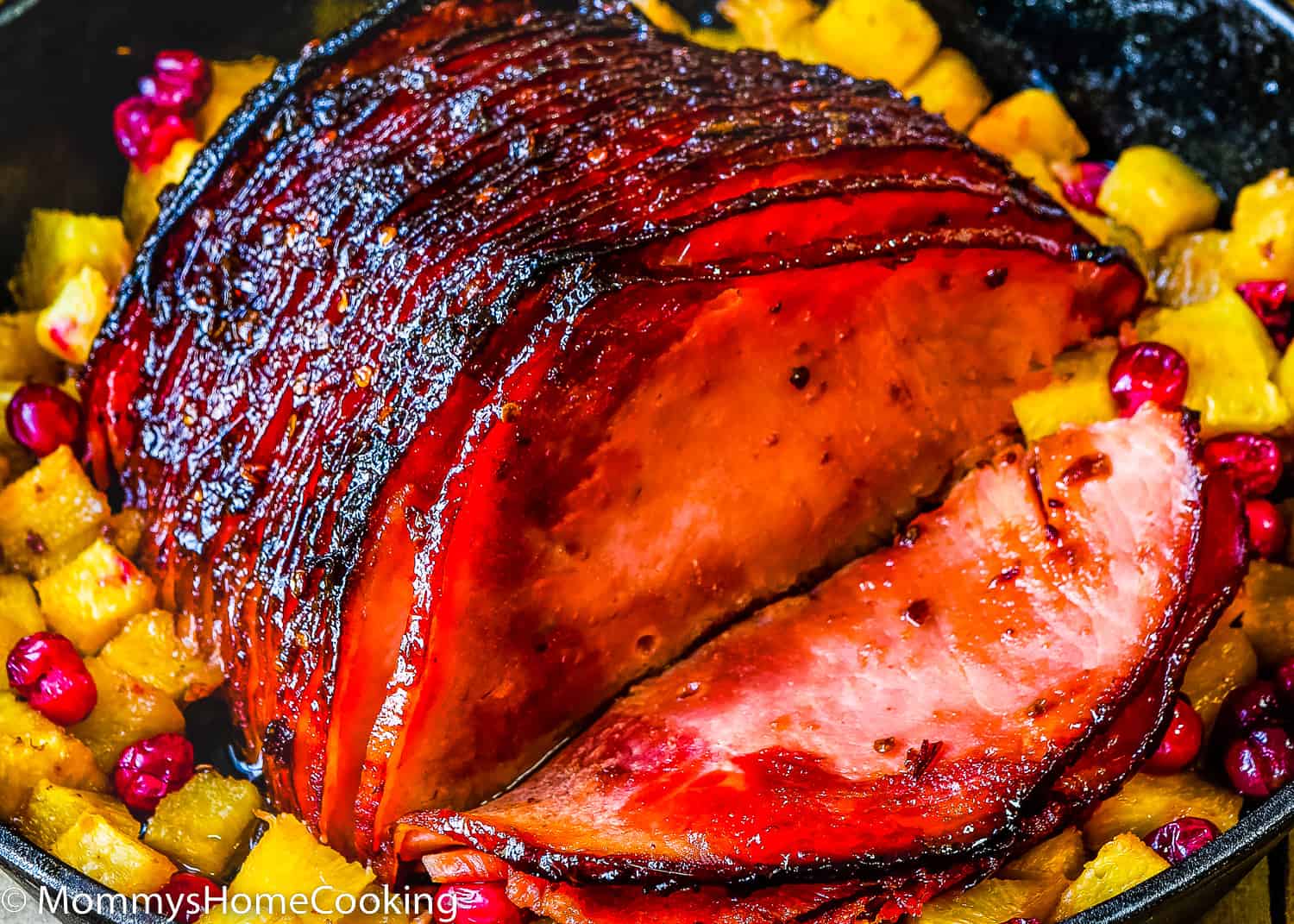 a sliced chipotle glazed ham in a cash iron skillet with chipotle sauce.