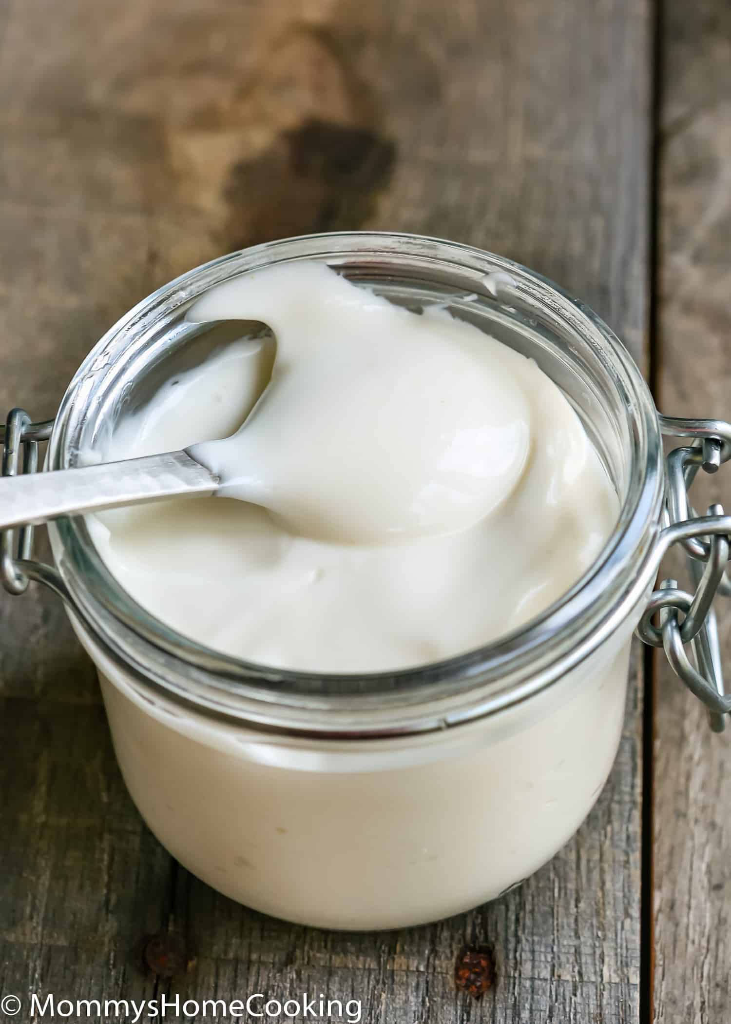 a spoon in a glass jar with egg-free mayonnaise.
