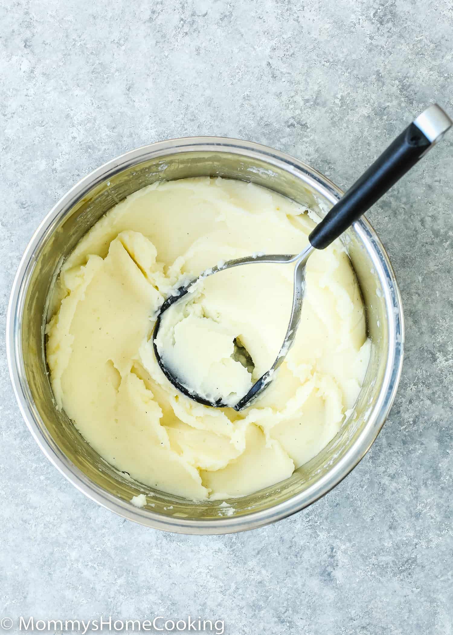 mashed potatoes in a instant pot with a potato smasher.
