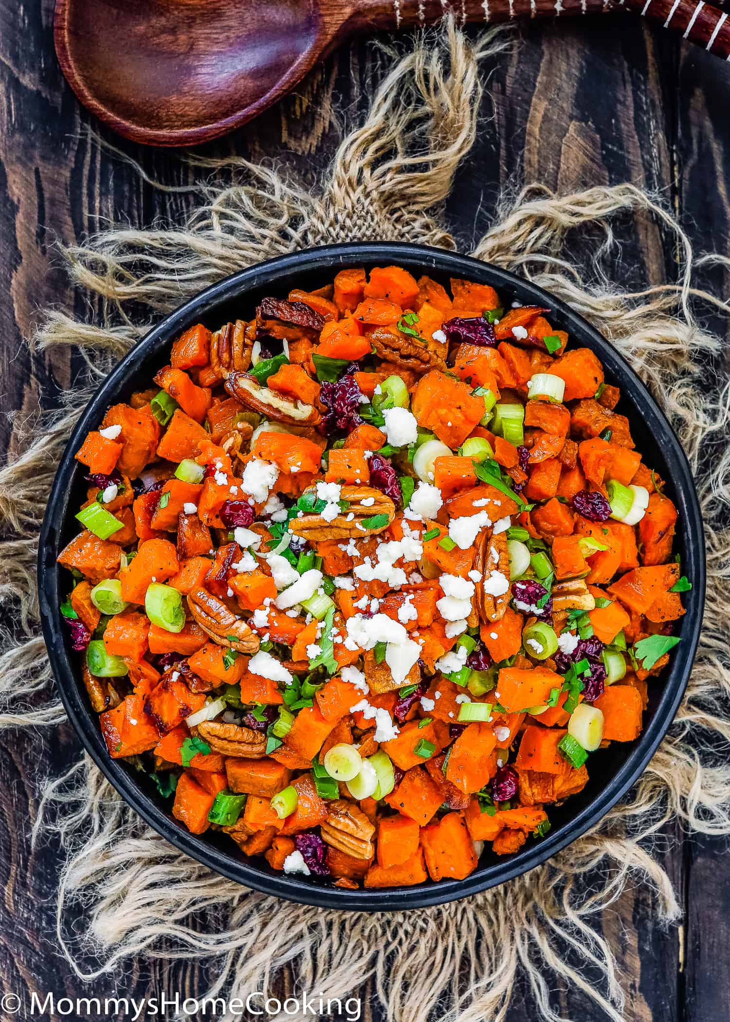 Roasted Sweet Potato and Cranberry Salad in a black serving bowl over a wooden surface.