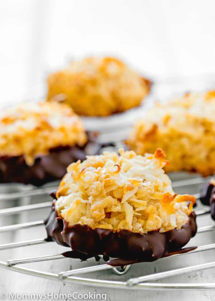 an Eggless Coconut Macaroon dipped in melted chocolate over a rack.