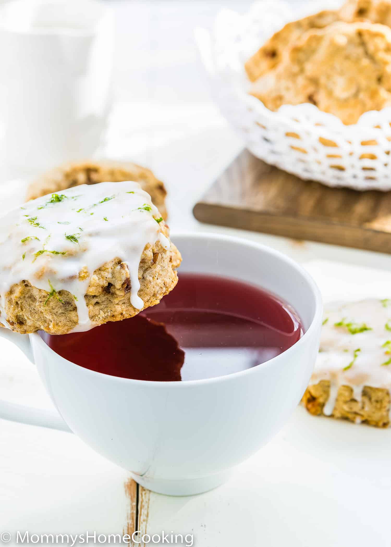 Eggless Gingerbread Scone with glaze over a cup of tea.