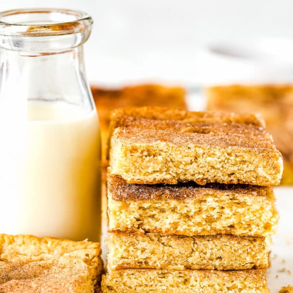 stack of four egg-free Snickerdoodle Bars next to a bottle with milk.